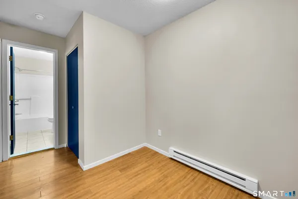a view of empty room with wooden floor