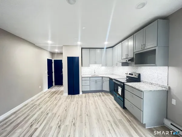 a large kitchen with a lot of counter space stainless steel appliances