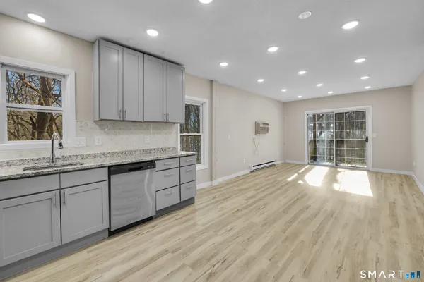 a kitchen with granite countertop wooden floors and wide window