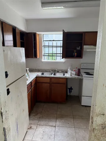 a kitchen with a refrigerator and a stove top oven