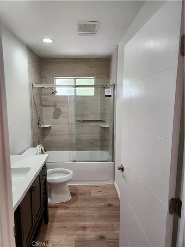 a bathroom with a bathtub shower sink mirror and toilet