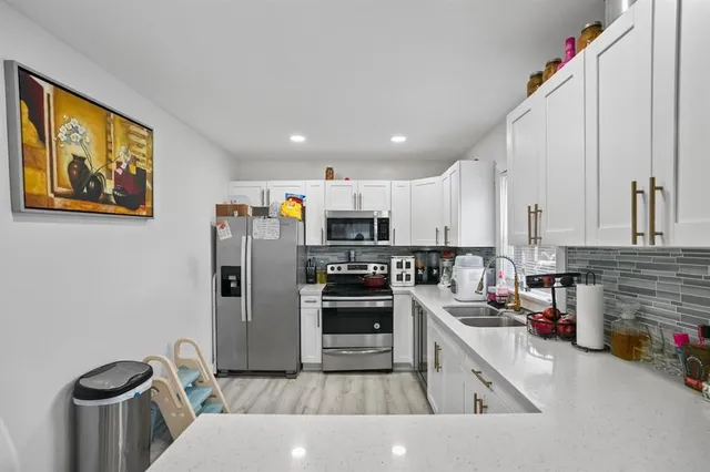 a kitchen with stainless steel appliances and a refrigerator