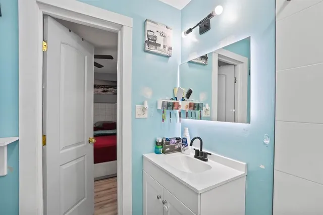 a bathroom with a sink vanity and a mirror