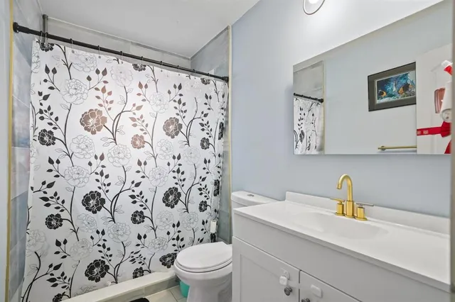 a bathroom with a sink a toilet and a shower curtain