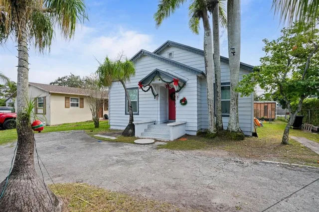 a view of a house with a yard and tree