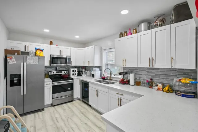 a kitchen with stainless steel appliances a sink a stove a refrigerator cabinets and a counter top space