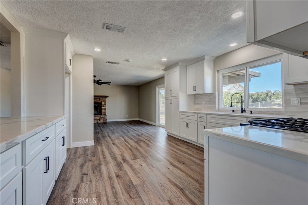 6572 Merced Road Oak Hills, CA 92344 - Photo 15 of 62 a large kitchen with granite countertop a large counter top a sink and stainless steel appliances