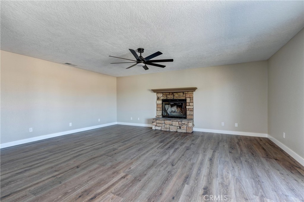 6572 Merced Road Oak Hills, CA 92344 - Photo 19 of 62 a view of wooden floor in a room with a ceiling fan