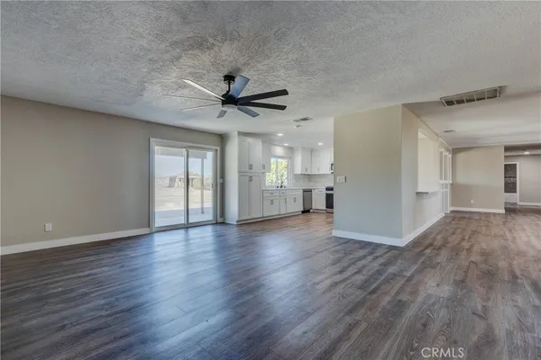a large white kitchen with kitchen island a sink stainless steel appliances and cabinets