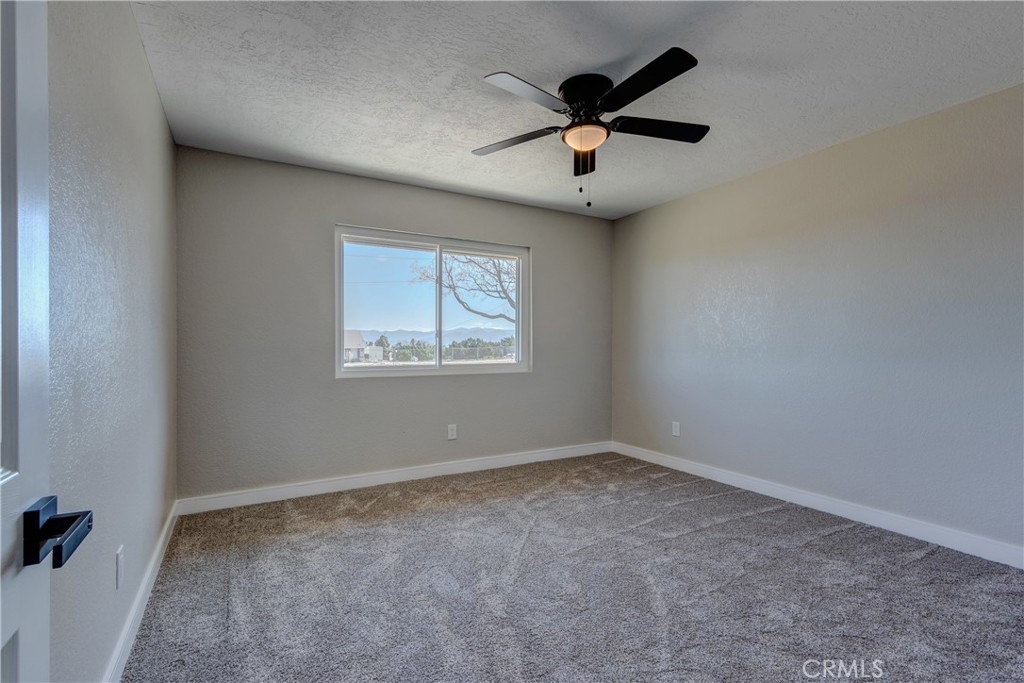 6572 Merced Road Oak Hills, CA 92344 - Photo 25 of 62 an empty room with ceiling fan and windows