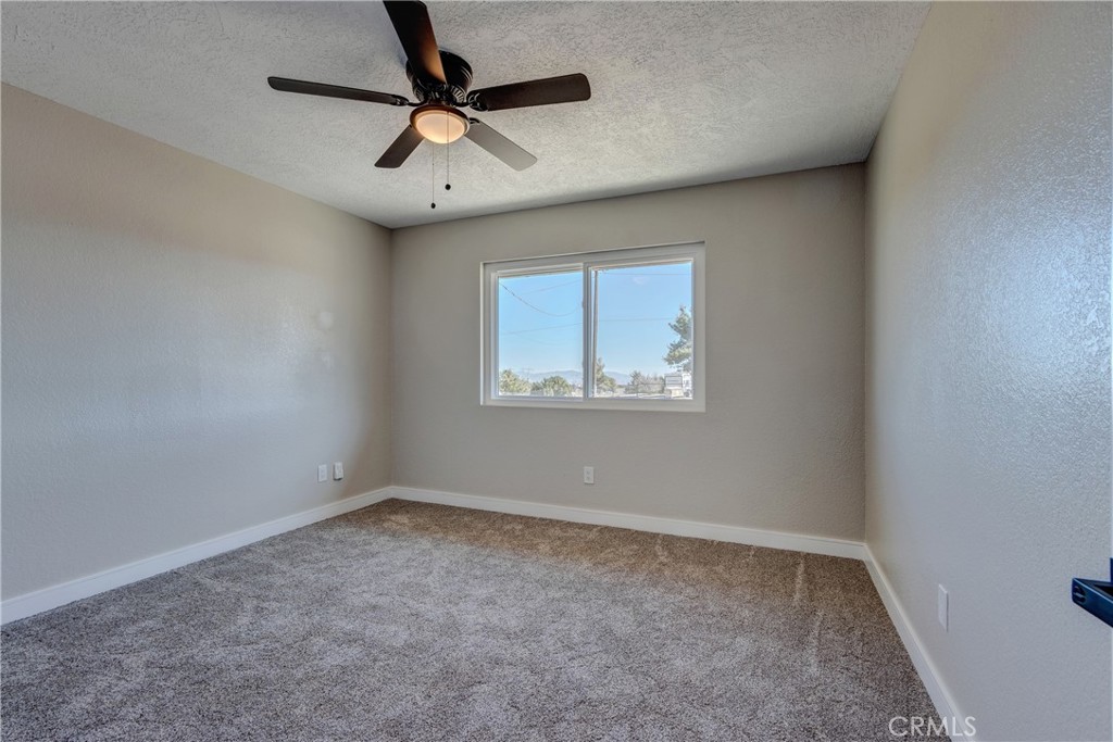 6572 Merced Road Oak Hills, CA 92344 - Photo 27 of 62 an empty room with a window and a fan