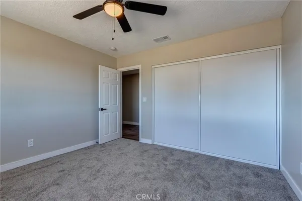 an empty room with windows and fan