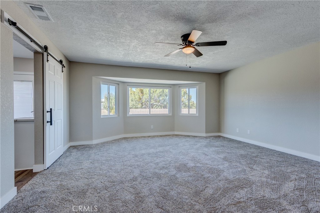 6572 Merced Road Oak Hills, CA 92344 - Photo 32 of 62 an empty room with windows and fan