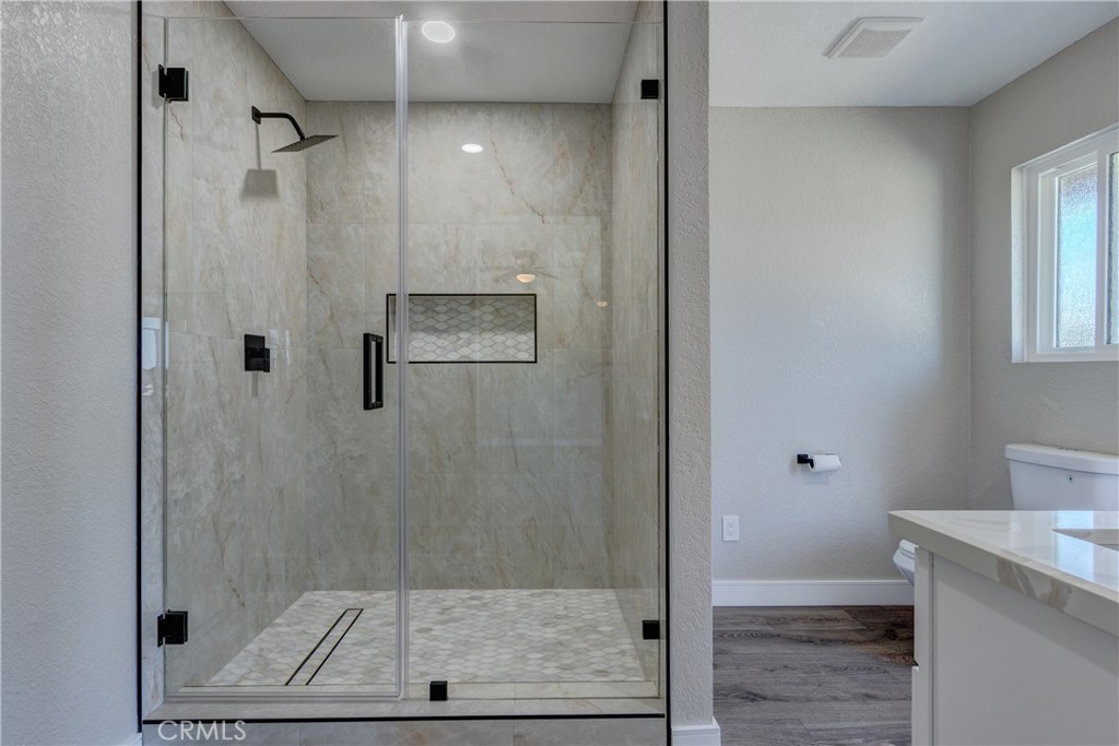 6572 Merced Road Oak Hills, CA 92344 - Photo 34 of 62 a bathroom with a shower and toilet
