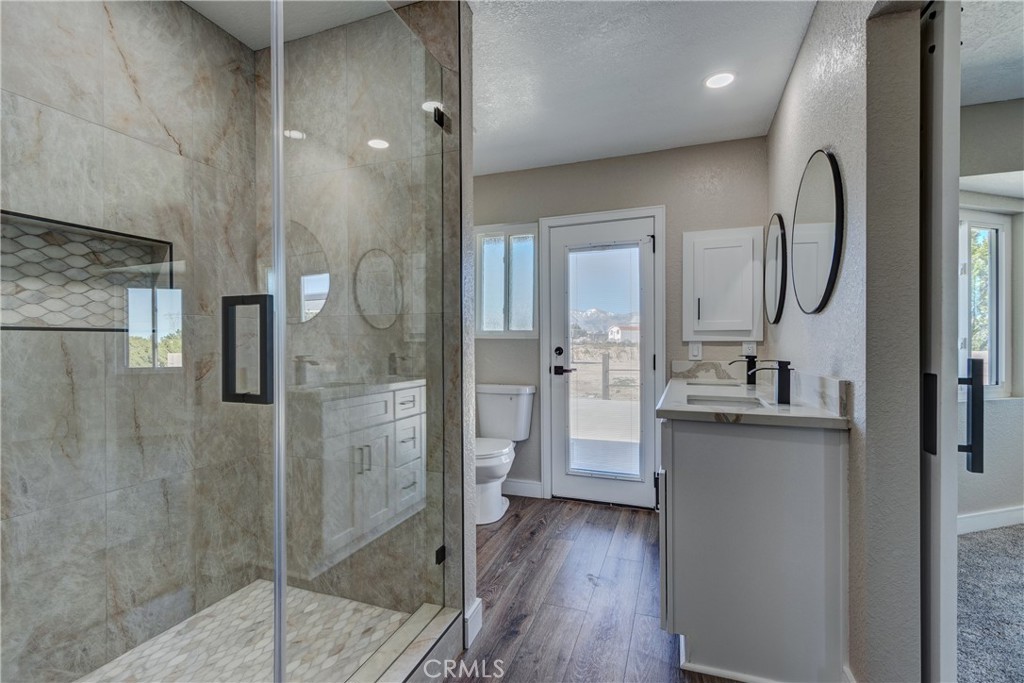 6572 Merced Road Oak Hills, CA 92344 - Photo 36 of 62 a bathroom with a granite countertop shower mirror and a sink