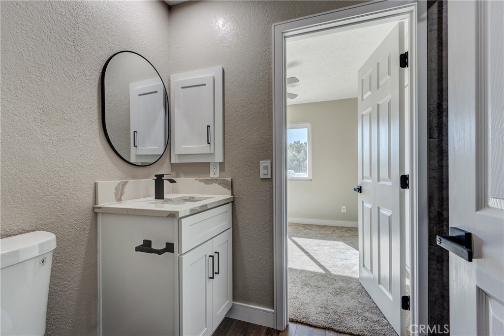 6572 Merced Road Oak Hills, CA 92344 - Photo 41 of 62 a bathroom with a sink a toilet and a mirror