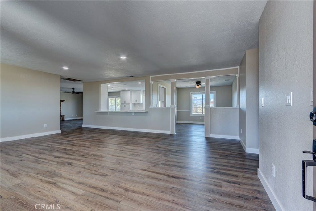 6572 Merced Road Oak Hills, CA 92344 - Photo 8 of 62 a view of an empty room with wooden floor and a window