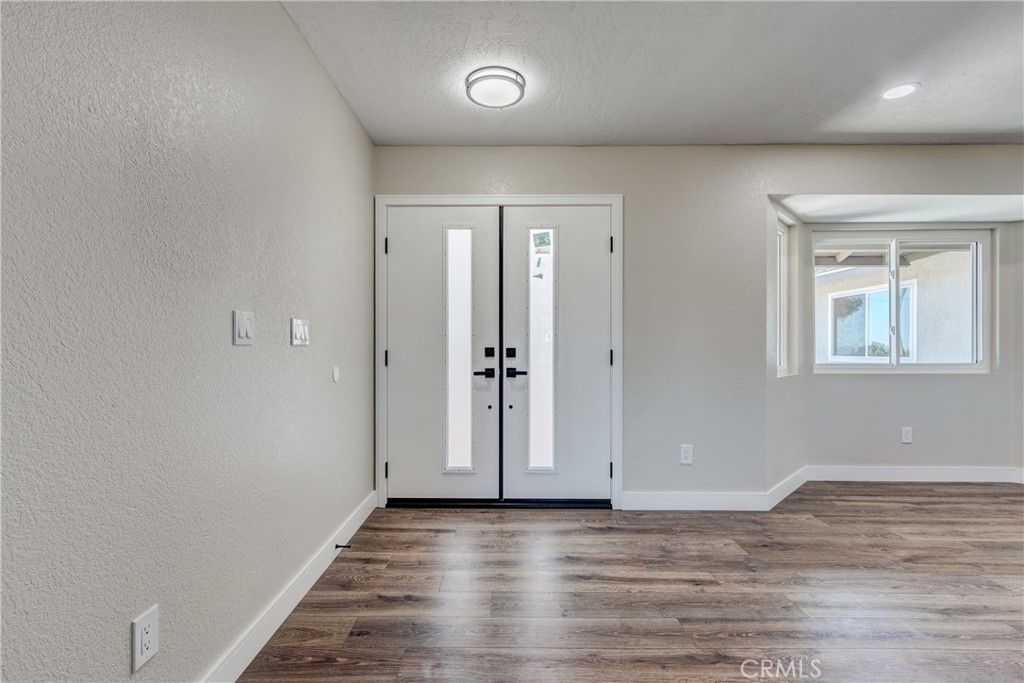 6572 Merced Road Oak Hills, CA 92344 - Photo 9 of 62 an empty room with wooden floor and windows