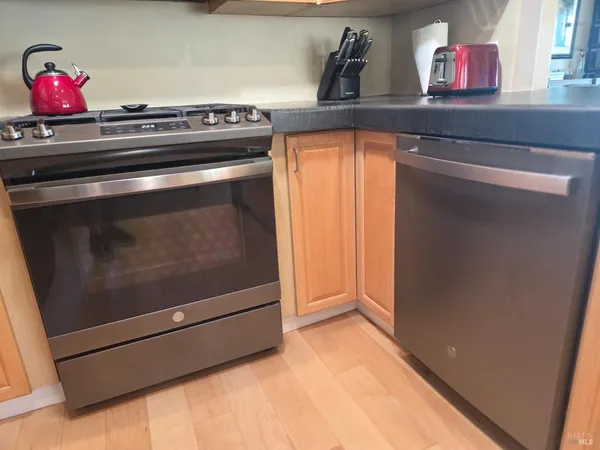a view of an empty room with wooden floor and stairs