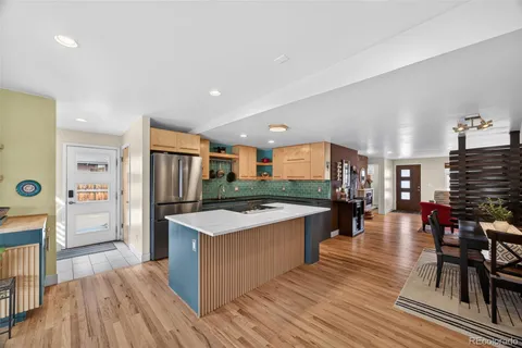 a large kitchen with stainless steel appliances kitchen island granite countertop a large center island and a wooden cabinets