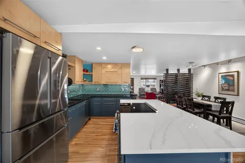 a kitchen with stainless steel appliances a refrigerator and a wooden cabinets