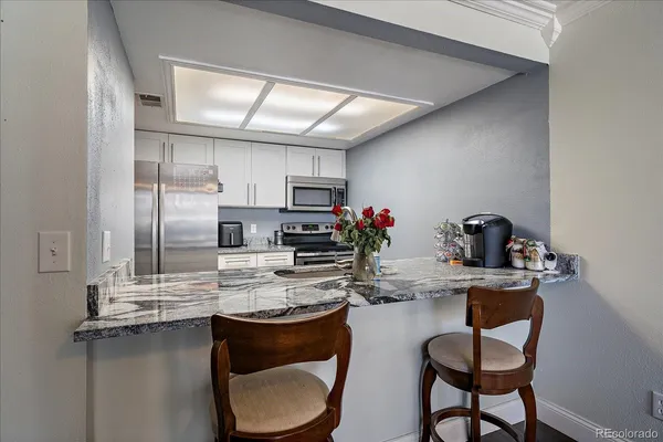 a kitchen with kitchen island a stove and a refrigerator