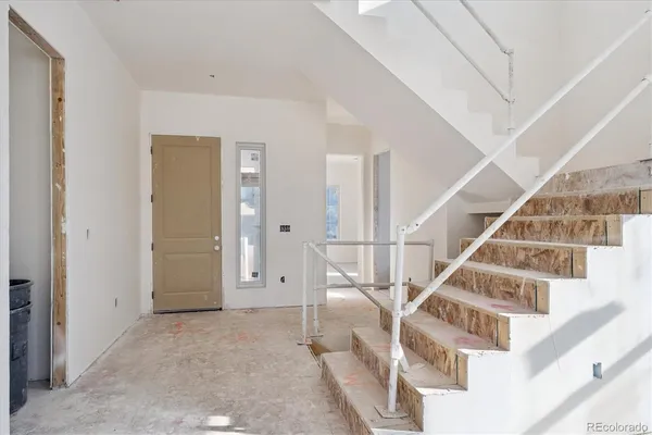 a large white kitchen with kitchen island a large window a sink and cabinets