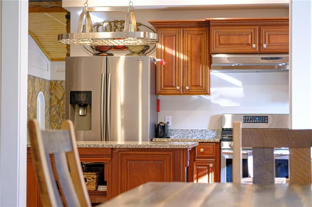437 Three Degree Road Butler, PA 16002 - Photo 20 of 25 a kitchen with stainless steel appliances granite countertop a refrigerator and wooden cabinets