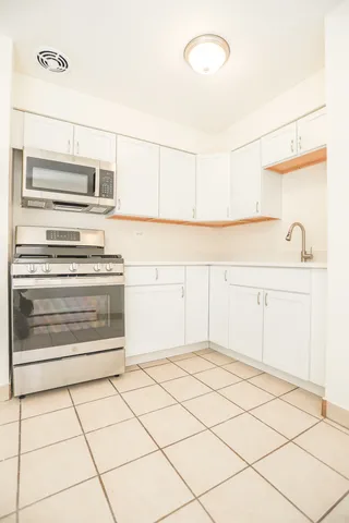 a kitchen with granite countertop a stove and a refrigerator