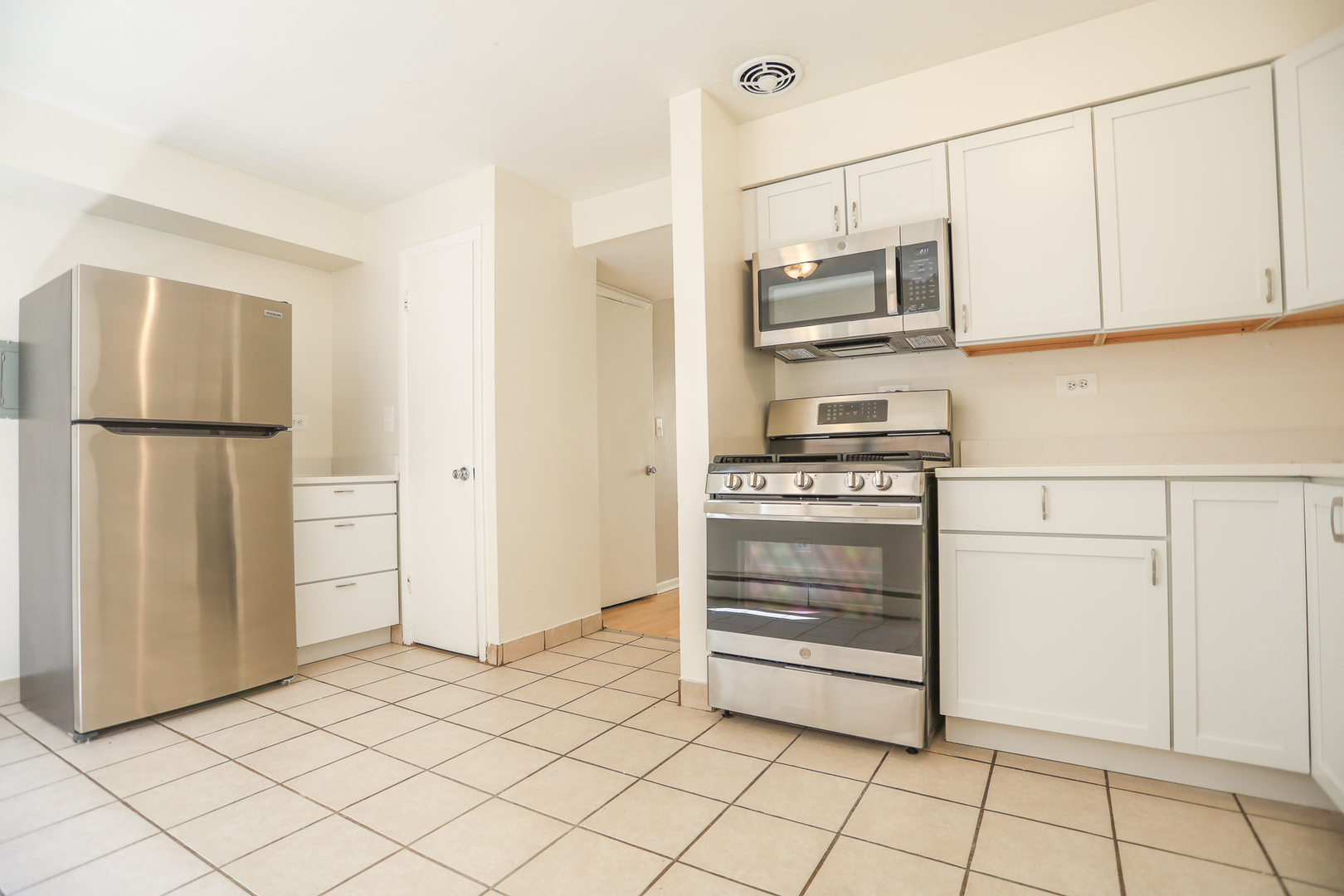 1660 West Pratt Boulevard, Unit 3S Chicago, IL 60626 - Photo 3 of 10 a kitchen with white cabinets and white appliances