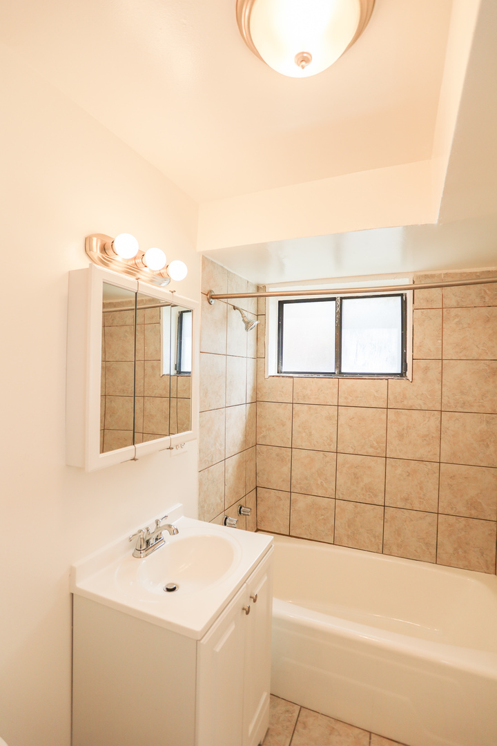 1660 West Pratt Boulevard, Unit 3S Chicago, IL 60626 - Photo 9 of 10 a bathroom with a sink a bathtub and next to a window