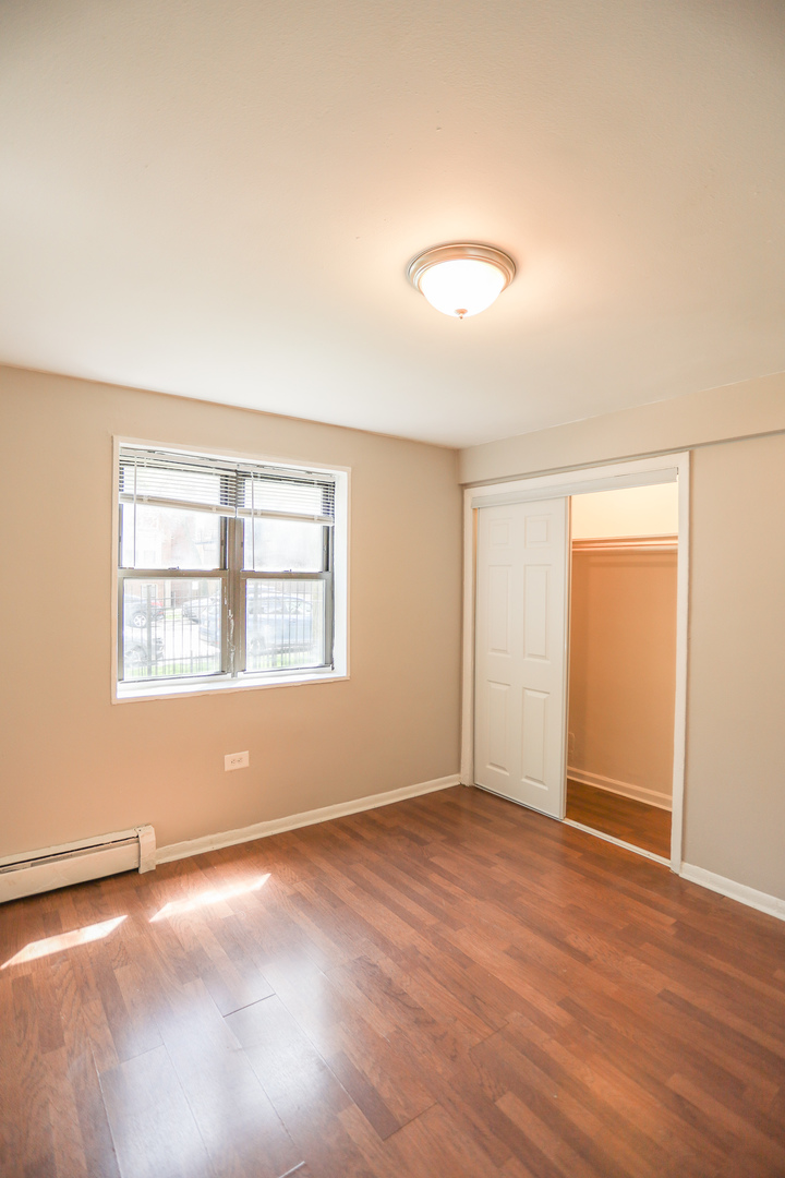 1660 West Pratt Boulevard, Unit 3S Chicago, IL 60626 - Photo 10 of 10 an empty room with wooden floor and windows