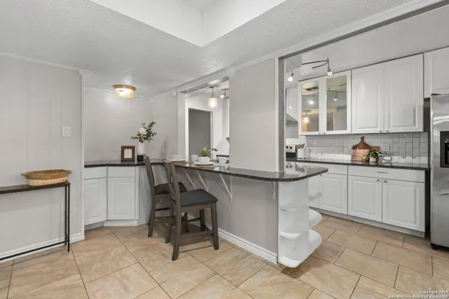 a kitchen with stainless steel appliances granite countertop a sink a counter space a stove and a wooden floors