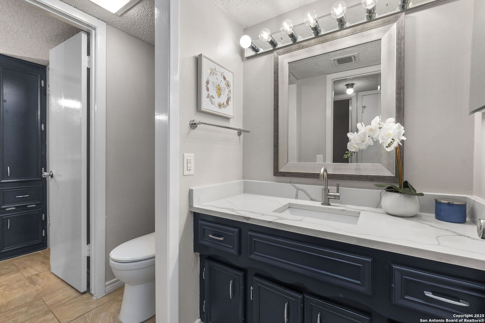 5203 Metcalf Windcrest, TX 78239 - Photo 23 of 37 a bathroom with a granite countertop toilet sink and mirror