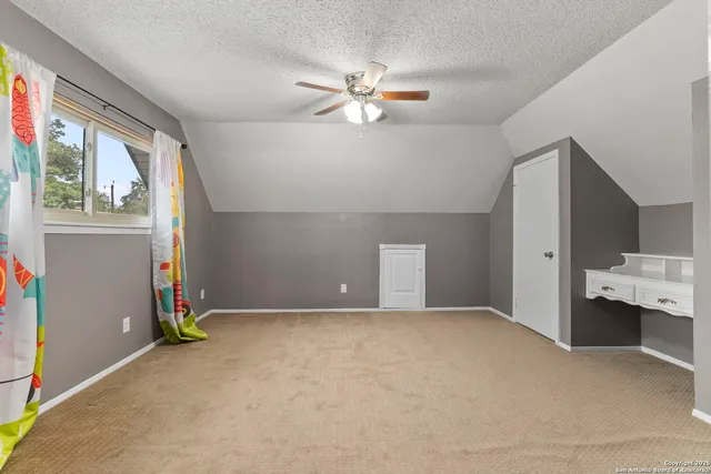 an empty room with window and ceiling fan