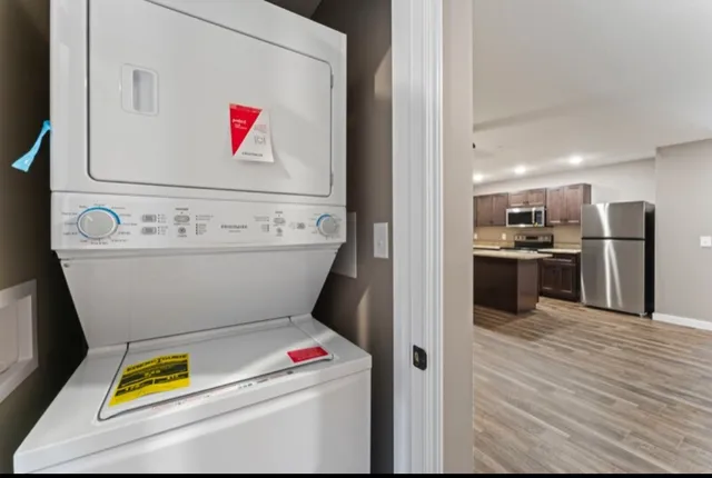 a room with stainless steel appliances furniture and a kitchen view