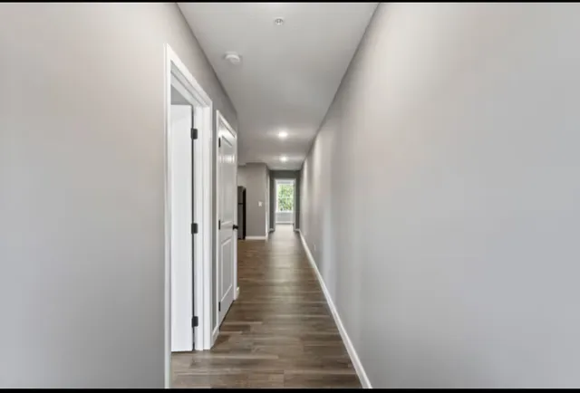 a view of hallway with wooden floor
