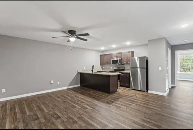 a large kitchen with stainless steel appliances granite countertop a refrigerator and a sink