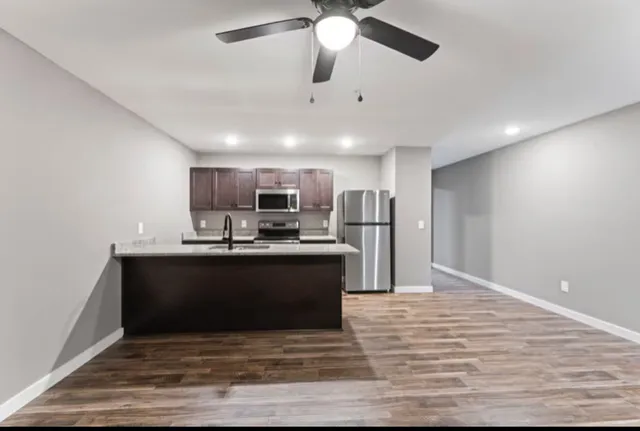 a view of kitchen with refrigerator stove and wooden floor