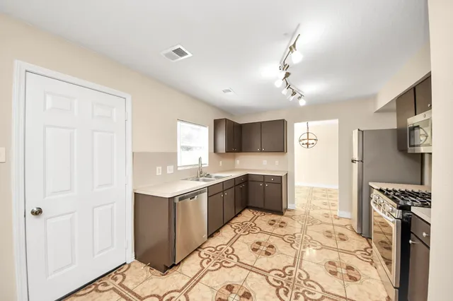a kitchen with a refrigerator sink and wooden floor