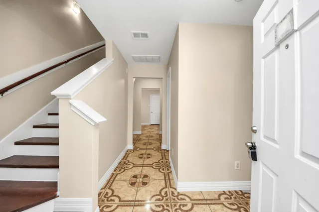 a view of a hallway with wooden floor and entryway