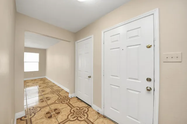 a view of a hallway with wooden floor and closet area