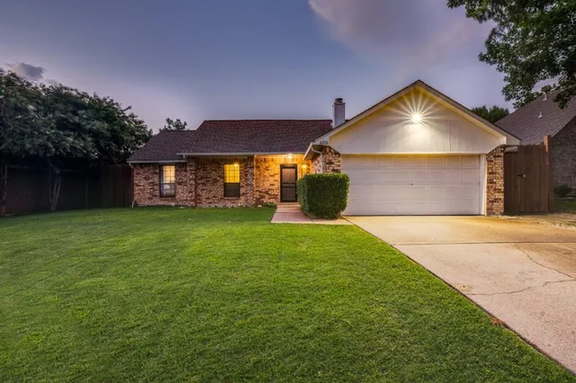 a front view of a house with a garden and yard