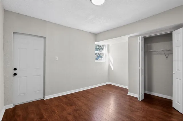 an empty room with wooden floor and closet