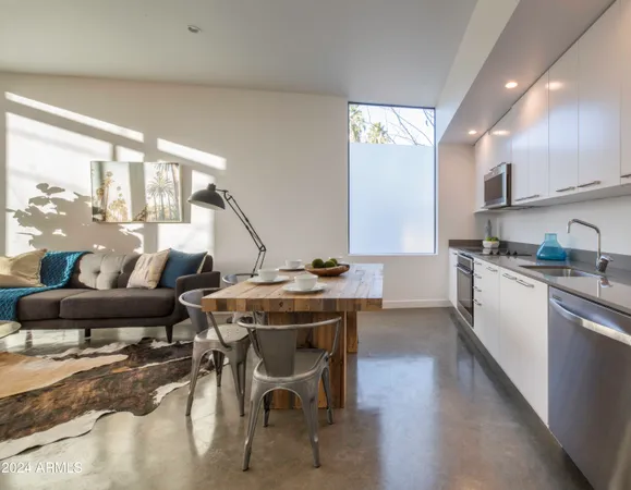 a kitchen with stainless steel appliances kitchen island granite countertop a table chairs sink and cabinets