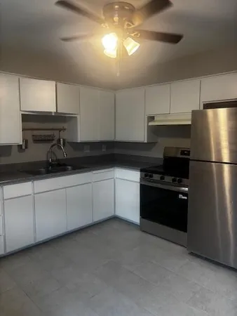 a kitchen with granite countertop white cabinets and stainless steel appliances