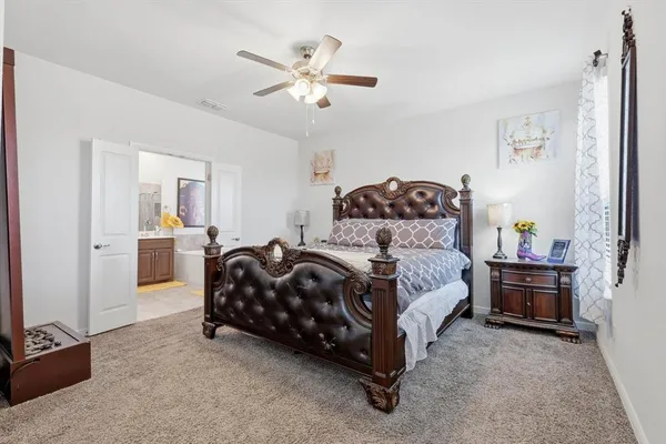 a spacious bedroom with a bed and a chandelier