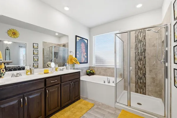 a bathroom with a tub sink shower and mirror