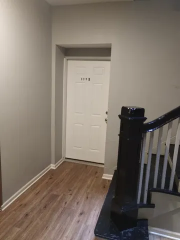 a view of a hallway with wooden floor and stairs