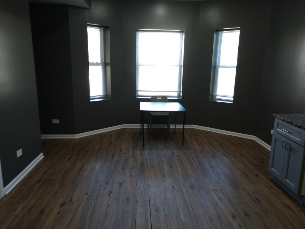 6219 South Rhodes Avenue Chicago, IL 60637 - Photo 20 of 24 a room with wooden floor and windows